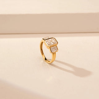 Angled view of a 14KT Yellow Gold diamond ring with a rectangular centre diamond and two rectangular side diamonds in bezel-style settings.