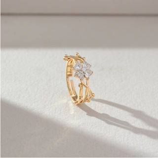 Side angled view of floral cluster diamond ring in yellow gold, featuring pear-shaped lab-grown diamonds in a petal formation with an open layered band. Set on a soft neutral backdrop, it highlights structure and sparkle.