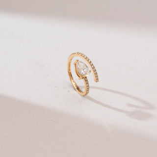 Top view of a 14KT yellow gold pear solitaire bypass diamond ring with a prong-set pear-shaped center stone and a curved pavé diamond band in an open wrap design.