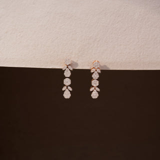 Front view of diamond drop earrings in 14 KT Yellow Gold, featuring cascading round and pear-shaped diamond clusters with marquise accents against a neutral backdrop.
