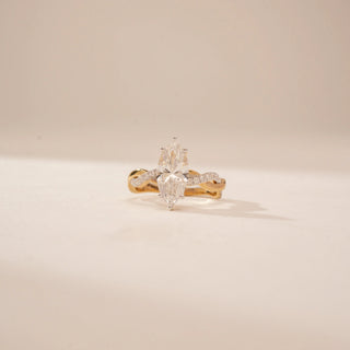 Front view of a 14KT Yellow Gold diamond ring, featuring two marquise-cut diamonds and a diamond-set crossover band.