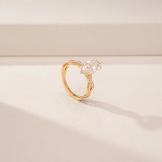 Angled view of a 14KT Yellow Gold diamond ring, featuring two marquise-cut diamonds and a diamond-set crossover band.