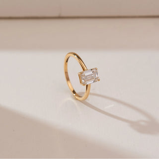 Side profile view of Minimalist Emerald Cut Diamond Ring in 14KT yellow gold, featuring a 1.2 carat emerald-cut centre diamond in a four-prong setting on a slim polished band.