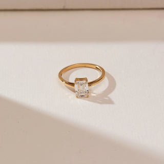 Top view of Minimalist Emerald Cut Diamond Ring in 14KT yellow gold, featuring a 1.2 carat emerald-cut centre diamond in a four-prong setting on a slim polished band.