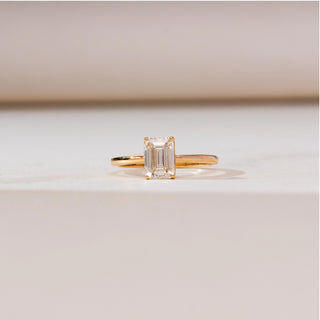 Front view of Minimalist Emerald Cut Diamond Ring in 14KT yellow gold, showcasing a 1.2 carat emerald-cut centre diamond in a sleek four-prong setting on a slim polished band.