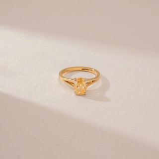 Top view of a diamond ring in 14KT Yellow Gold, featuring alternating oval  diamond in a beige backdrop.