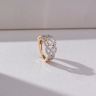 Side view of Interlocking Halo Diamond Ring in 14KT Yellow Gold, featuring a round lab grown diamond centre with linked halo motifs. Set on a beige backdrop, the design highlights depth and intricate brilliance.
