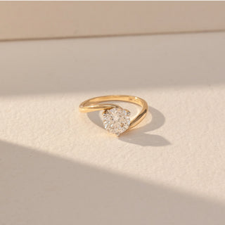Top view of Round Solitaire Diamond Ring in 14KT Yellow Gold, featuring a centred round lab grown diamond in prong setting with a twisted band. Set on a beige backdrop, the design highlights symmetry and elegance.
