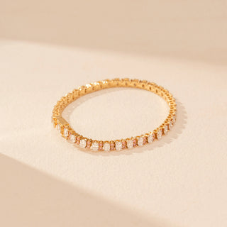 Top view of a 14KT dual gold bracelet featuring oval-cut diamonds, set against a beige background.