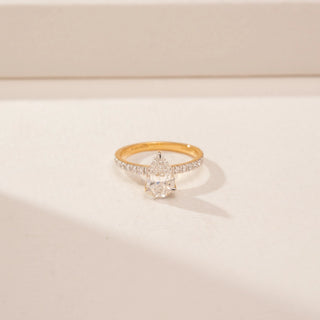 Close-up view of a 14KT Yellow Gold diamond ring, featuring pear and round diamonds with a diamond-set band.