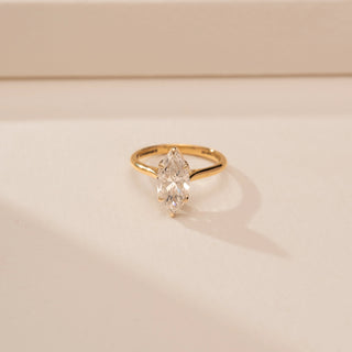 Close - up view of a 14KT Yellow Gold diamond ring with a marquise centre diamond in a four-prong setting.
