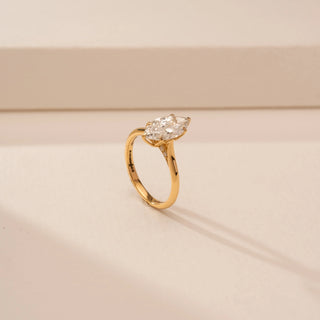 Angled view of a 14KT Yellow Gold diamond ring with a marquise centre diamond in a four-prong setting.