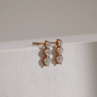 Side view of the Triple-Drop Solitaire Diamond Earrings, emphasizing the structured rose gold frame and bombay screw closure. The 1-carat EF VVS solitaires catch the light from every angle, creating a refined yet striking silhouette.
