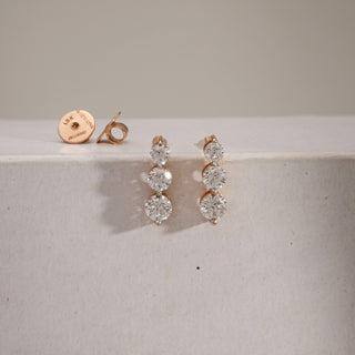 Front view of the Triple-Drop Solitaire Diamond Earrings in 18KT rose gold, showcasing three perfectly aligned solitaires in a cascading drop design. Each diamond is EF VVS clarity, set with fine precision to maximize brilliance and elegance.