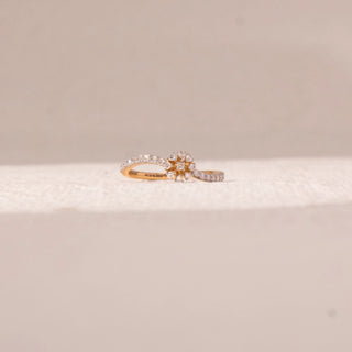 Front view of floral curve diamond ring in yellow gold, featuring a central flower cluster with round lab-grown diamonds and a split pavé band. Placed on a soft beige surface, the design reflects graceful brilliance.