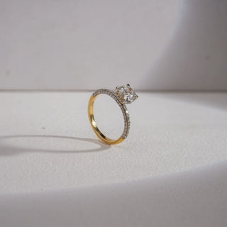 Angle view of Radiant Glow Solitaire Diamond Ring in 14KT Yellow Gold, featuring a 0.6 carat EF VVS round solitaire with pavé-set diamonds on the band, symbolising timeless elegance and luxury.