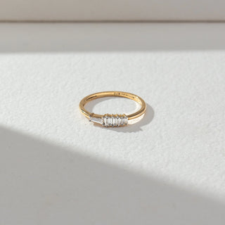 Top view of Baguette Diamond Band Ring in 14KT Yellow Gold, featuring a row of baguette-cut lab grown diamonds in prong setting. Set on a beige backdrop, the design highlights symmetry and refined brilliance.
