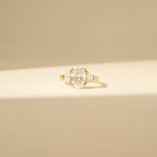 Front view of Oval Three-Stone Diamond Ring in 14KT Yellow Gold, featuring an oval centre diamond with pear-shaped side diamonds.