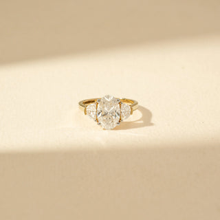 Close-up view of Oval Three-Stone Diamond Ring in 14KT Yellow Gold, featuring an oval centre diamond with pear-shaped side diamonds.