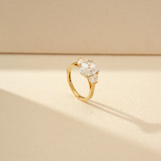 Angled view of Oval Three-Stone Diamond Ring in 14KT Yellow Gold, featuring an oval centre diamond with pear-shaped side diamonds.