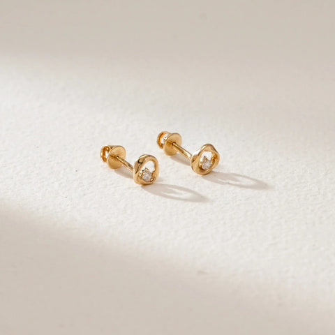 Whirlwind Gleam Diamond Gold Studs in 18KT Yellow Gold, featuring sculptural open-circle design with EF-VVS lab-grown round diamonds at the centre, placed on a softly lit neutral surface.