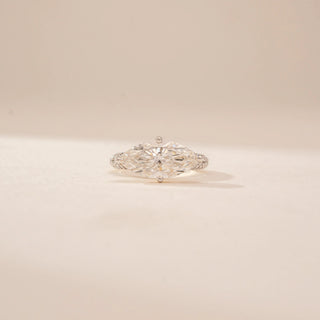 Close up view of a 14KT Yellow Gold diamond ring, featuring two marquise-cut diamonds and a diamond-set band.