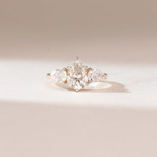 Front view of 14KT yellow gold three-stone ring featuring a central pear-shaped diamond flanked by two matching pear-cut side diamonds in a classic trinity design.