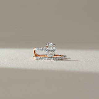 Front view of oval diamond ring in rose gold, featuring a centred oval lab-grown diamond on a split pavé band. Placed on a soft beige surface, the design reflects modern elegance and brilliance.
