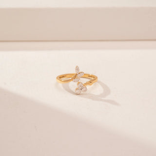 Close up view of a 14KT Yellow Gold diamond ring, featuring marquise and round diamonds in a floral design.