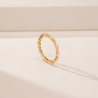 Angled view of a 14KT Yellow Gold diamond band with alternating round and oval diamonds in a linked design.