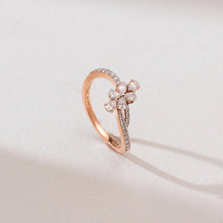 Angled front view of Rose Gold Blossom Diamond Ring in 14KT rose gold, featuring a five pear-shaped diamond flower with a curved pavé-set diamond bypass band.