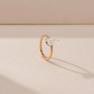 Angled view of Pear Diamond Solitaire Ring in 14KT Yellow Gold, featuring a pear-shaped diamond on a sleek band.