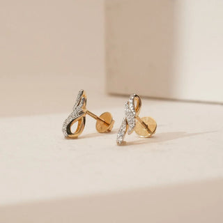 Side view of triple wave diamond earrings showing curved yellow gold structure with pavé-set round lab-grown diamonds and secure screw-back closure, placed on a soft neutral surface.