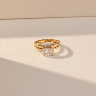Top view of Oval Solitaire Diamond Ring in 14KT Yellow Gold, featuring a centred oval lab grown diamond with a split band. Set on a beige backdrop, the design highlights symmetry and refined elegance.
