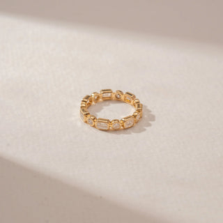 Close-up view of a 14KT Yellow Gold diamond eternity ring featuring alternating round and rectangular bezel-set diamonds in a continuous pattern.