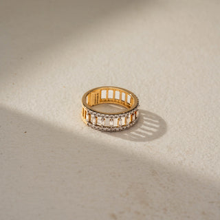 Top view of a geometric diamond statement band in 14 KT Yellow Gold, featuring vertically set baguette-cut lab-grown diamonds framed by pavé-set round diamond rows in an openwork design, displayed against a beige backdrop.
