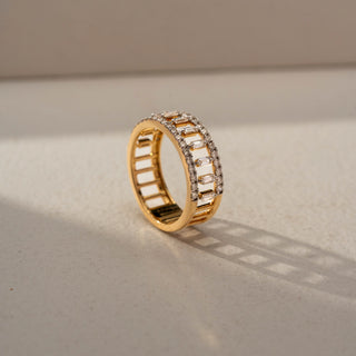Angled view of a geometric diamond statement band in 14 KT Yellow Gold, featuring vertically set baguette-cut lab-grown diamonds framed by pavé-set round diamond rows in an openwork design, displayed against a beige backdrop.