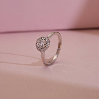 Angled view of 14KT White Gold Classic Diamond Halo Engagement Ring featuring round EF VVS solitaire with pavé halo diamonds, symbolising timeless love and radiant elegance.