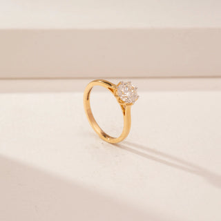Angled view of a 14KT Yellow Gold diamond ring, featuring a round centre diamond in a scalloped setting.
