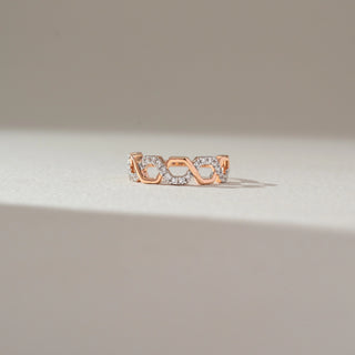 Front view of geometric diamond band ring in rose gold, featuring hexagonal links with alternating lab-grown diamond-studded and plain segments. Captured against a soft beige background with gentle shadows.