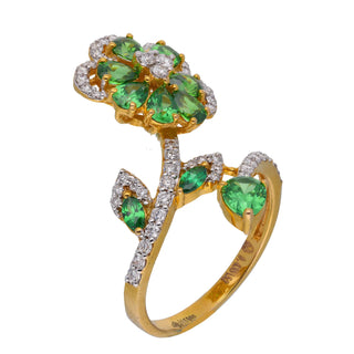 A side view of a female ring of size 14  weighing 4.26 grams is displayed on a white background, showcasing an intricate design. Crafted from 14 KT yellow gold and 0.435-carat lab-grown diamond, it is complemented by vibrant green gemstones, arranged in an elaborate floral pattern. The ring's elegant composition features delicate diamond accents that accentuate the radiant gems, creating a captivating look.