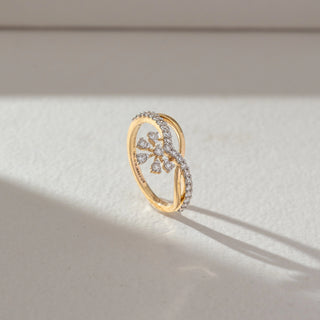 Side profile of floral diamond ring in yellow gold, featuring petal-shaped lab-grown diamonds with a curved diamond-studded band. Captured against a soft beige textured background.