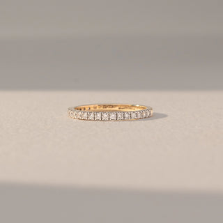 Front view of Pavé Diamond Band Ring in 14KT Yellow Gold, featuring a continuous row of round lab grown diamonds in pavé setting. Set on a beige backdrop, the design highlights fine sparkle and elegance.
