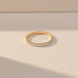 Top view of Pavé Diamond Band Ring in 14KT Yellow Gold, featuring a continuous row of round lab grown diamonds in pavé setting. Set on a beige backdrop, the design highlights symmetry and fine sparkle.
