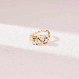 Top view of Serpentine Duo Diamond Ring in 14KT yellow gold, featuring a round and pear-cut diamond set on a flowing S-shaped Toi et Moi bypass band.
