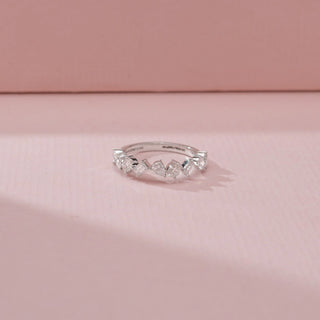 Close-up view of a 14KT White Gold diamond band featuring alternating round, pear and baguette-cut diamonds.