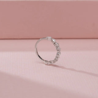 Side view of a 14KT White Gold diamond band featuring alternating round, pear and baguette-cut diamonds.