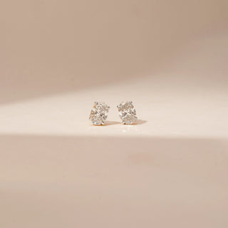 Front view of 14KT Yellow Gold diamond earrings featuring oval centre diamonds with surrounding diamond accents in stud settings.