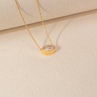 Angled  view of Oval Solitaire Diamond Pendant in 14KT Yellow Gold, featuring a bezel-set oval lab-grown diamond on a fine chain.