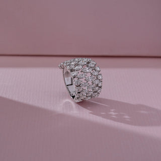Side angled view of wide diamond band ring in white gold, featuring multiple rows of marquise-shaped lab-grown diamonds forming an open lattice design. Set on a soft pink backdrop, it highlights bold structure and brilliance.
